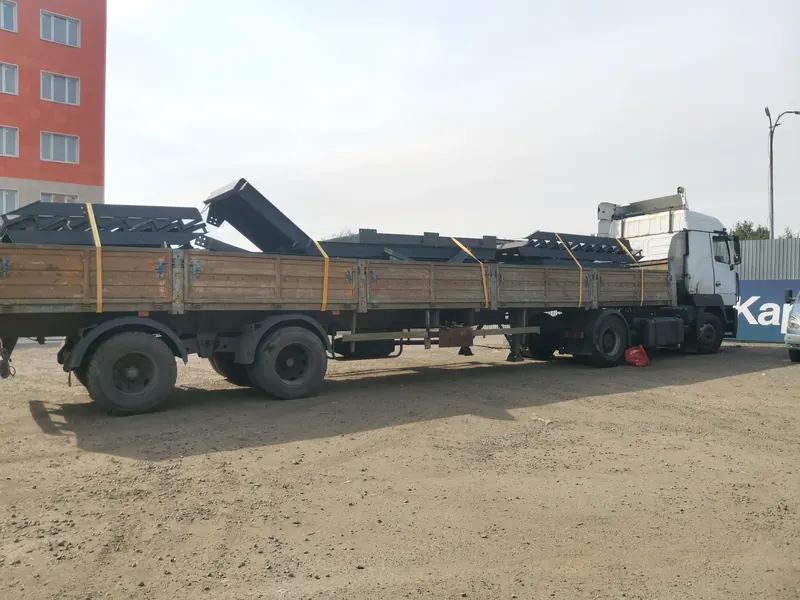 Длинные стальные балки и профиль на бортовом полуприцепе