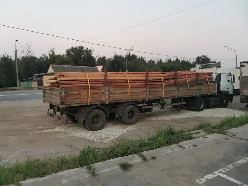 Пачки пиломатериалов на бортовом полуприцепе
