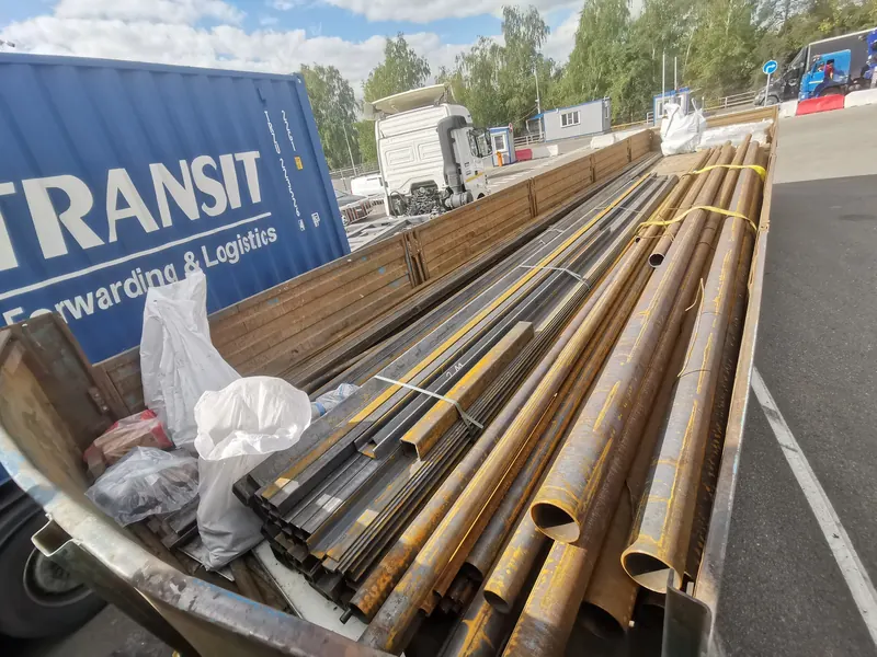 Длинные стальные трубы разных диаметров на открытом полуприцепе