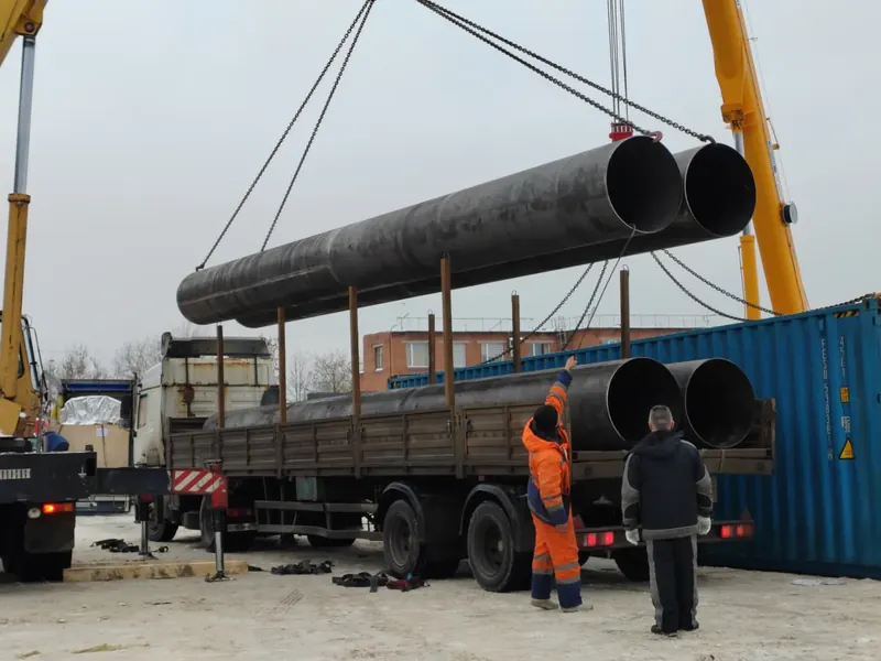 Погрузка нескольких труб большого диаметра автокраном зимой